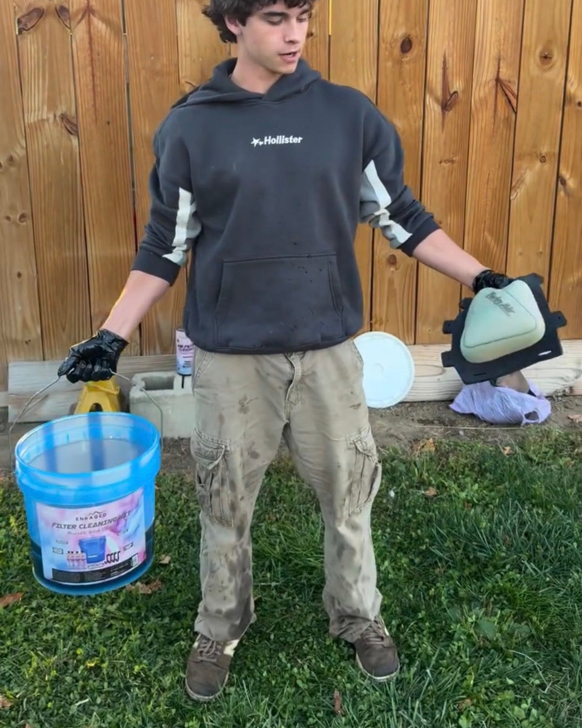 Rider holding the Enraged filter cleaning kit bucket and a foam air filter.